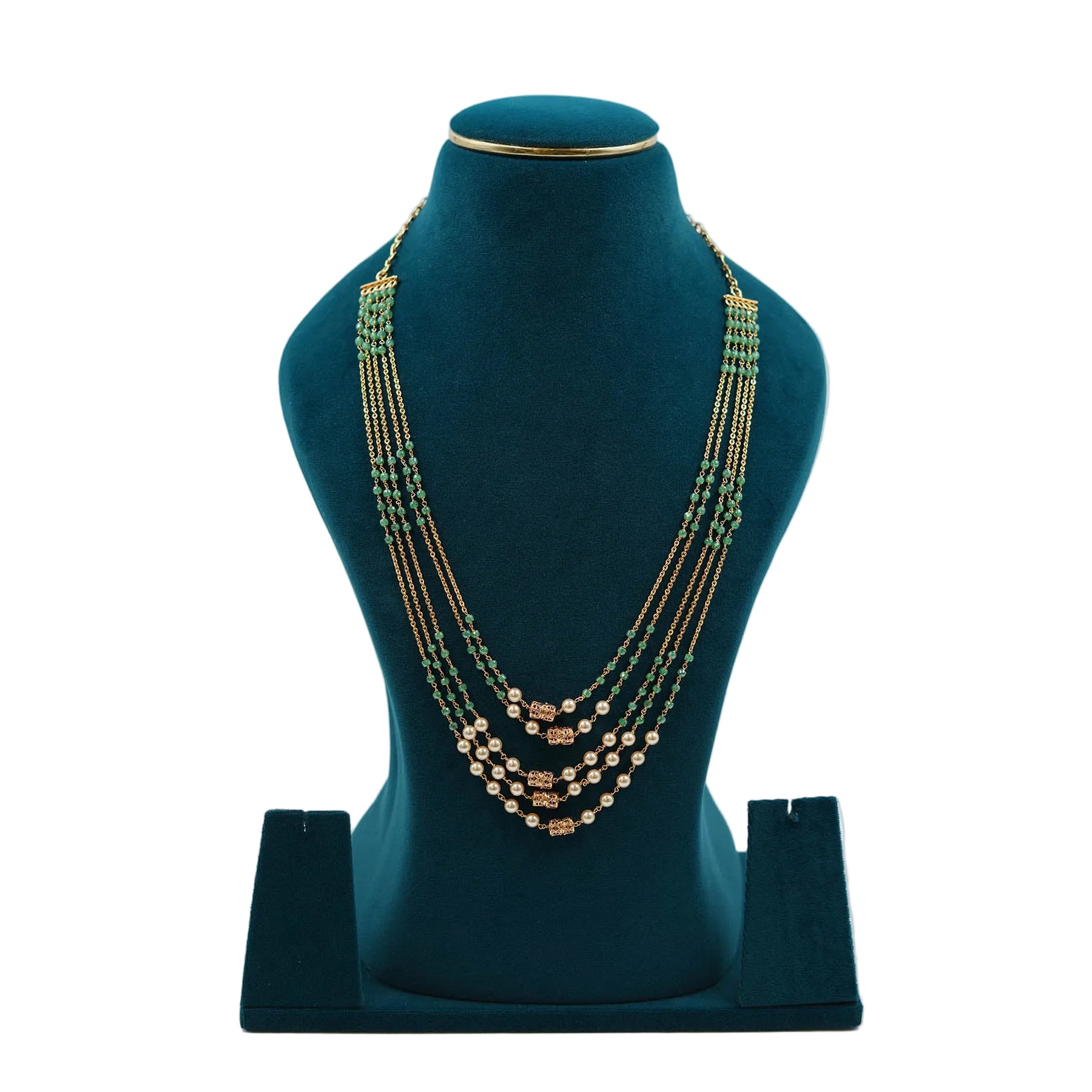 Lalithambike traditional multi-strand emerald and gold bead necklace, featuring four layers of green beads accented with white pearls and intricate gold cylindrical spacers on a teal display.
