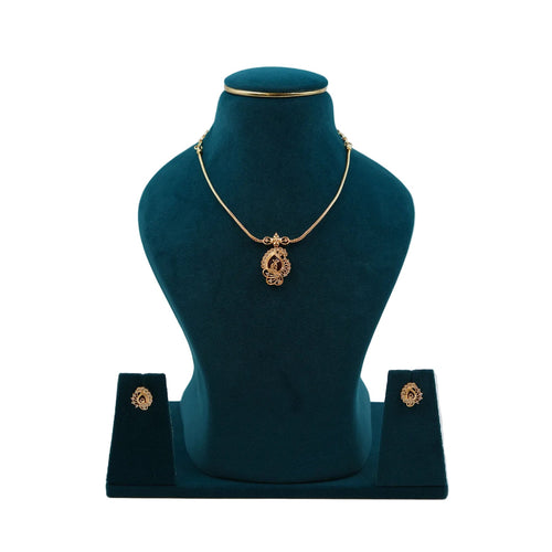 Lalithambike 1-gram gold pendant set featuring a modern filigree design with a ruby-toned center stone and matching stud earrings on a teal jewelry bust.