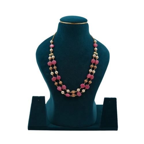 Lalithambike traditional two-strand necklace featuring vibrant pink square beads, cream pearls, and 1-gram gold filigree spacers on a teal jewelry bust.