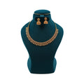 Lalithambike 1-gram gold antique necklace featuring a repeating filigree leaf-drop fringe and matching bell-shaped Jhumka earrings on a teal jewelry bust.