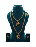 Lalithambike 1-gram gold bridal combo set featuring a short necklace, long haram, maang tikka, and ruby-accented earrings on a teal display.