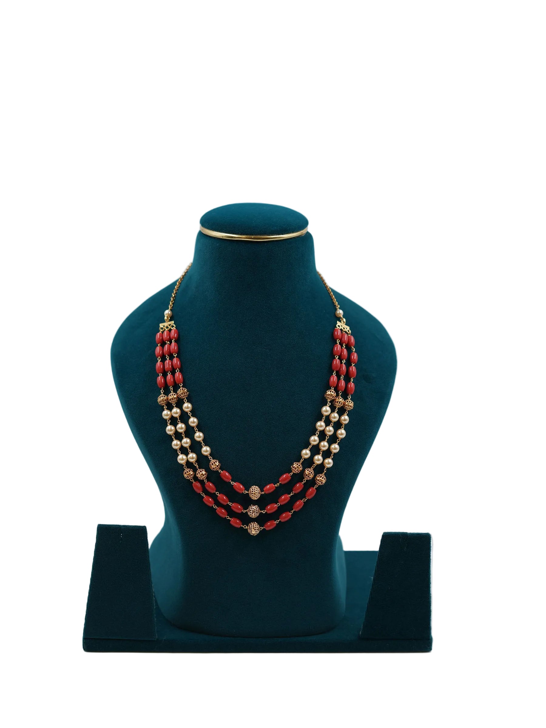 Lalithambike three-strand necklace featuring alternating deep red coral beads, cream pearls, and gold filigree accents on a teal jewelry bust.