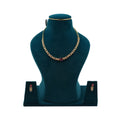 Lalithambike delicate 1-gram gold necklace featuring a leaf-motif chain and an oval ruby-toned center stone, with matching drop earrings on a teal jewelry bust.